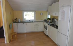 uma cozinha com electrodomésticos brancos e piso em madeira em Awesome Home In Nex With 3 Bedrooms And Wifi em Spidsegård