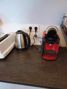 eine Küchentheke mit einem Toaster und einem Wasserkocher in der Unterkunft Grand F3 CONFORTABLE 5 mn de Paris et proche Disneyland in Maisons-Alfort