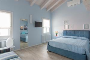 a blue bedroom with a bed and a mirror at Tiffany Home in Burano
