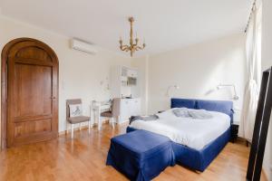 Schlafzimmer mit einem blauen Bett und einem Tisch in der Unterkunft Residenza del Cedro in Rom