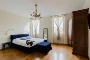 sypialnia z niebieskim łóżkiem i żyrandolem w obiekcie Residenza del Cedro w Rzymie