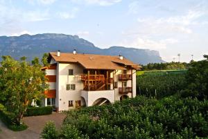 una casa en un campo con montañas en el fondo en Waldthalerhof, en Monticolo