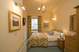 a bedroom with a bed and a window at Loch Leven Hotel & Distillery in Glencoe