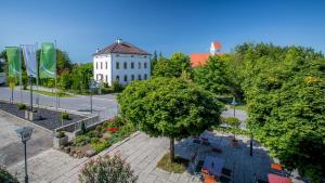 a tree in front of a white building at Hotel Parsberg in Puchheim in Puchheim