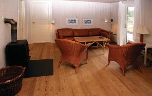 un soggiorno con un divano, un tavolo e delle sedie di Three-Bedroom Holiday Home In Romo a Mølby