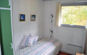 a bedroom with a bed with pillows and a window at Holiday Home Uranusvej in Ålbæk