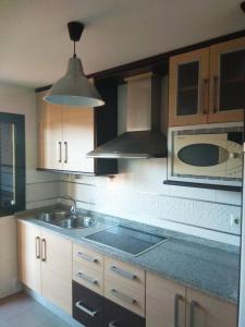 eine Küche mit einer Spüle und einer Mikrowelle in der Unterkunft Islantilla Palmeras Golf 2 in Islantilla