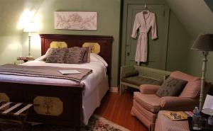 1 dormitorio con cama y albornoz colgado en la pared en Longacre of Appomattox, en Appomattox