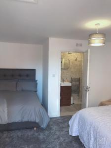 ein Schlafzimmer mit einem Bett und ein Badezimmer mit einem Waschbecken in der Unterkunft Flat 1 - Entire Modern Studio with en-suite and free Parking close to QMC, City centre & Notts Uni in Nottingham