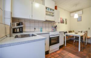 a kitchen with a sink and a table in it at Lovely Apartment In Ebeltoft With Outdoor Swimming Pool in Ebeltoft