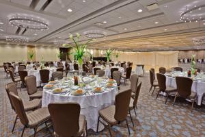 a banquet hall with white tables and chairs at Crowne Plaza Chicago O'Hare Hotel & Conference Center by IHG in Rosemont +37 photos