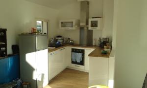 a kitchen with white cabinets and a refrigerator at La Maison Bleue in Banyuls-sur-Mer