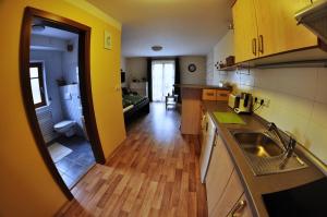 eine Küche mit gelben Wänden, Holzböden und einem Waschbecken in der Unterkunft Apartmá Krkonoše in Martinice