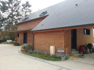 a house with a garage with a roof at Maison bois in Germigny-des-Prés