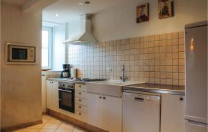 a kitchen with white cabinets and a sink at Vakantiewoning 9 in Simpelveld