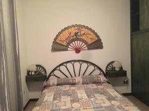 カーラゴノネにあるCasa Nuraghe Arvuのベッドルーム1室(装飾的なヘッドボード付きのベッド1台付)