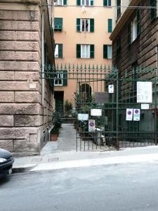 un bâtiment avec des panneaux sur une clôture à côté d'une rue dans l'établissement ArtRoom in appartment, à Gênes