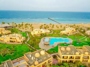 an aerial view of a resort with a pool and the ocean at Wadi Lahmy Azur Resort - Soft All-Inclusive in Abū Ghuşūn