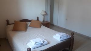 a bedroom with a bed with towels on it at San Luis Centro in San Luis