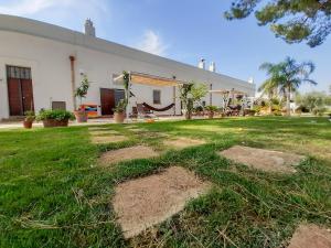 una casa con un patio con césped y un edificio en Agriturismo La Stornara en Ginosa Marina