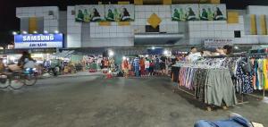 een markt met kleding op rekken voor een gebouw bij NHÀ NGHỈ VIỆT NGA in Ha Tien