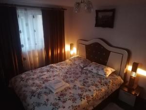 a bedroom with a bed with a book on it at Vila Perla Govorei in Băile Govora