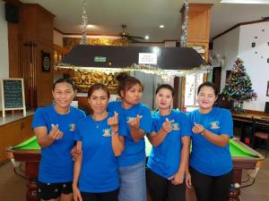 a group of women in blue shirts standing in front of a pool table at Andaman Sea Guesthouse Patong in Patong Beach