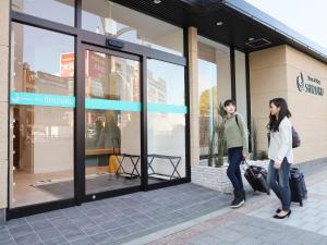 Dos mujeres están de pie fuera de un escaparate en Smart Stay SHIZUKU Ueno Ekimae, en Tokio