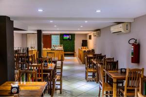 a dining room with wooden tables and chairs at Hotel Trilhos de Minas in São João del Rei