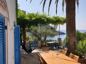 a patio with a table and chairs and a view of the ocean at Appartamenti Villa Lina in Nisporto