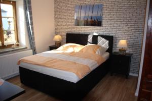 a bedroom with a large bed with a brick wall at Fiskerhytte - Meine Fischerhütte in Börgerende-Rethwisch