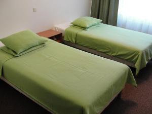 twee bedden naast elkaar in een kamer bij Hotel Madona in Madona
