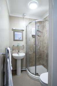 y baño con ducha y lavamanos. en The Causeway Guest House, en March