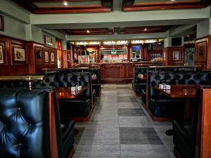 un bar con asientos de cuero negro en un restaurante en Tangra Hotel, en Stara Zagora