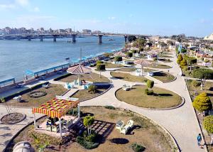 a park next to the water with a bridge at Minya Compound of the Armed Forces in Minya