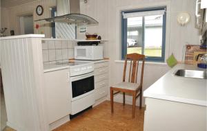 EgernsundにあるNice Home In Grsten With House A Panoramic Viewのキッチン(白いコンロ、電子レンジ付)