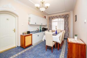 a kitchen and dining room with a table and chairs at Villa Rosa in Hajdúszoboszló +10 photos