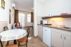 a kitchen and dining room with a table and chairs at Villa Rosa in Hajdúszoboszló