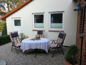 una mesa con un mantel blanco en el patio en Altes Zollhaus, en Fehmarn