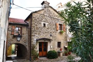 una vieja casa de piedra con un arco delante de ella en Villa Antica, en Grožnjan