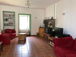 a living room with a red couch and a tv at Large 100 year old house in lovely walking area in Fayet-Ronaye