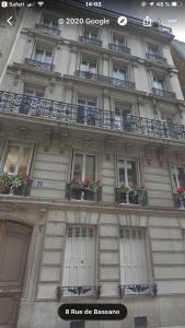 a building with windows and balconies with flowers on it at BASSANO in Paris