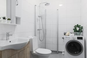 a bathroom with a sink and a washing machine at Linne Apartment in Uppsala