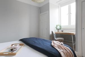 a bedroom with a bed with a blue blanket on it at Linne Apartment in Uppsala