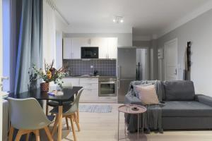 a living room with a couch and a table and a kitchen at Linne Apartment in Uppsala