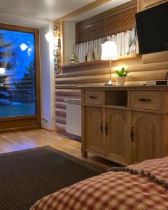 a bedroom with a bed and a television in a room at Siumno Izba B&B Brzegi in Brzegi