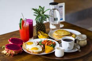 una mesa con dos platos de desayuno y una taza de café en Jago Gili Air, en Gili Air