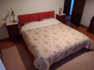 a bedroom with a large bed with a red headboard at Balkone in Montagna (Μπαλκόνι στο Βουνό ) in Metsovo