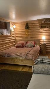 a bedroom with a bed with a wooden wall at Siumno Izba B&B Brzegi in Brzegi