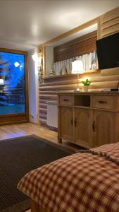a bedroom with a bed and a television in a room at Siumno Izba B&B Brzegi in Brzegi